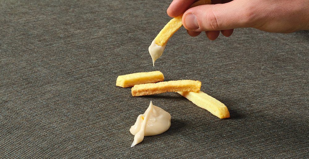 Fritten Auf dem Sofa befinden sich Pommes und Mayonnaise. Das soll zeigen wie pflegeleicht die Stoffbezüge von Sensoo sind.